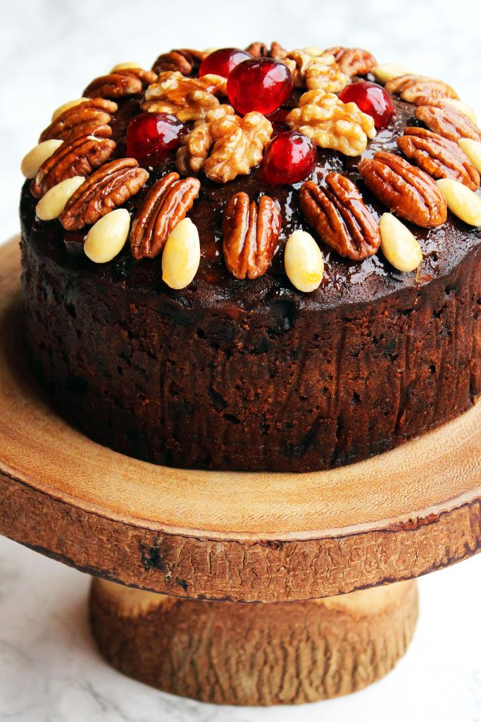 This Naked Christmas Cake looks like a decoration with glazed fruit and nuts on top. Get the recipe at Supper in the Suburbs!
