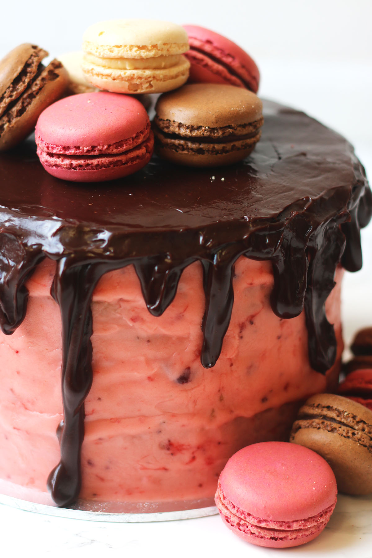 Neapolitan cake - layers of vanilla and chocolate sponge covered in real strawberry buttercream and chocolate ganache and topped with macarons