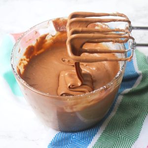 Melted chocolate, condensed milk and butter being beaten with an electric whisk