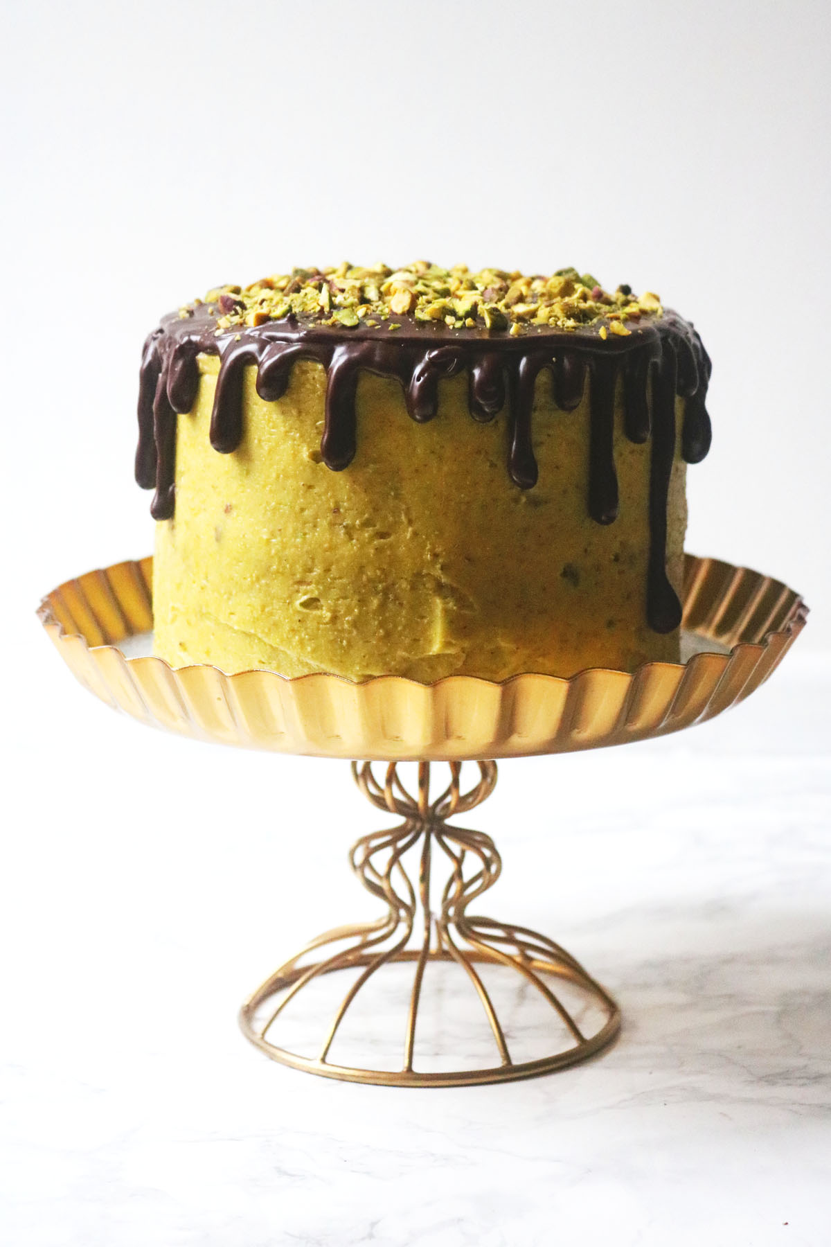 Chocolate and Pistachio Cake on a gold cake stand