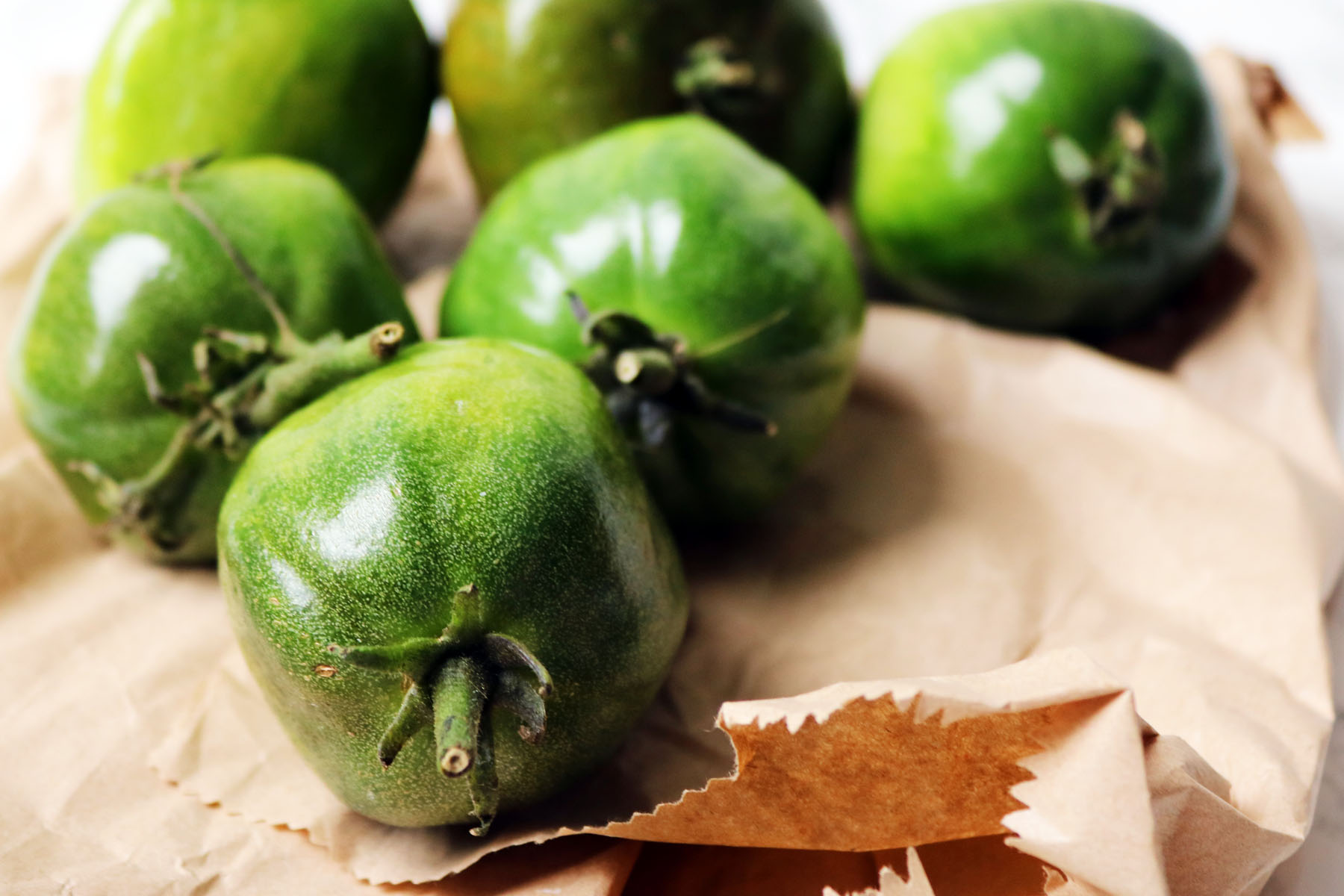 Green tomatoes and a brown paper bag
