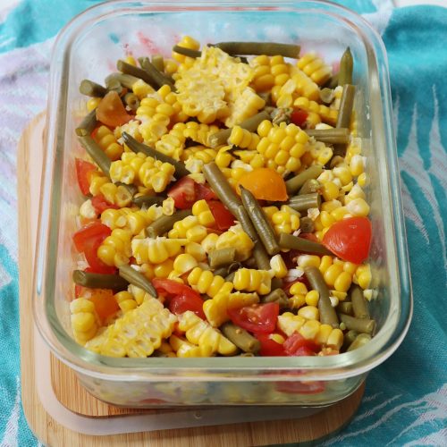 Sweetcorn, green bean and tomato salad in a glass container with bamboo lid