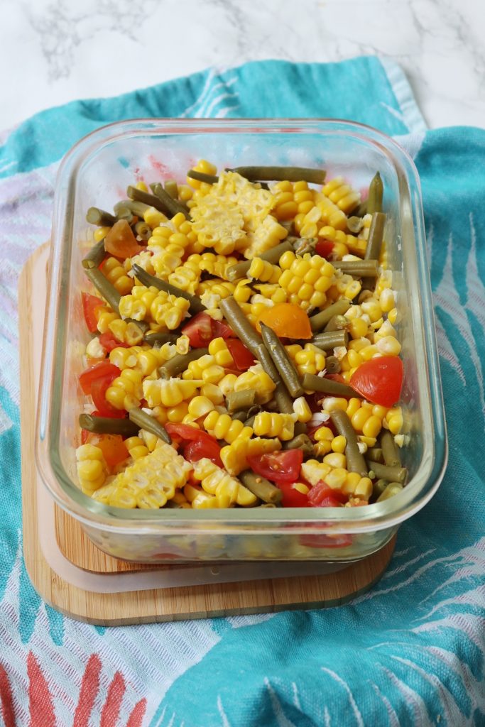 Sweetcorn, green bean and tomato salad in a glass container with bamboo lid