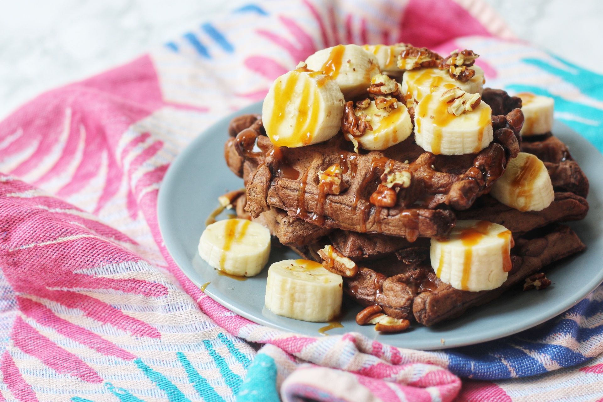 Chocolate Sourdough Waffles topped with banana, caramel and nuts