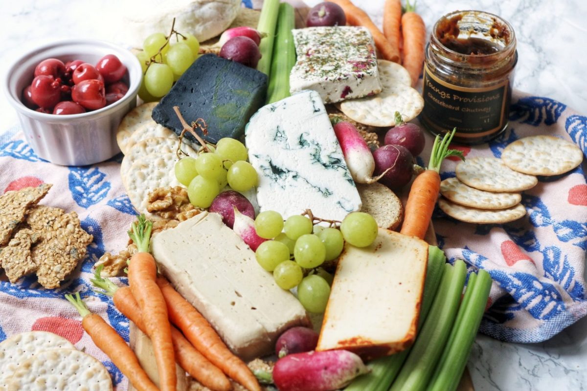 A selection of vegan cheeses with crackers, fruits, nuts, chutney and veg
