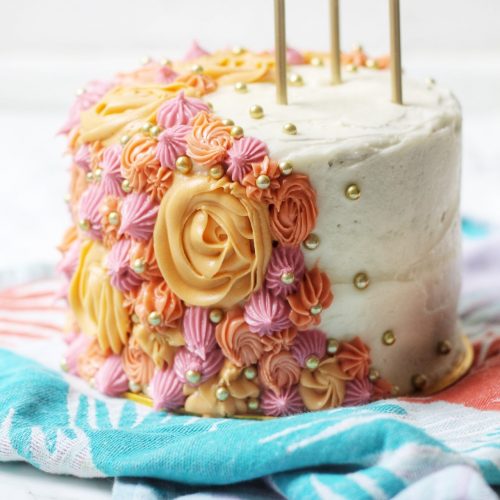 Close up of piped flowers on a Vegan Carrot Cake decorated with Plant Based Cream Cheese Frosting