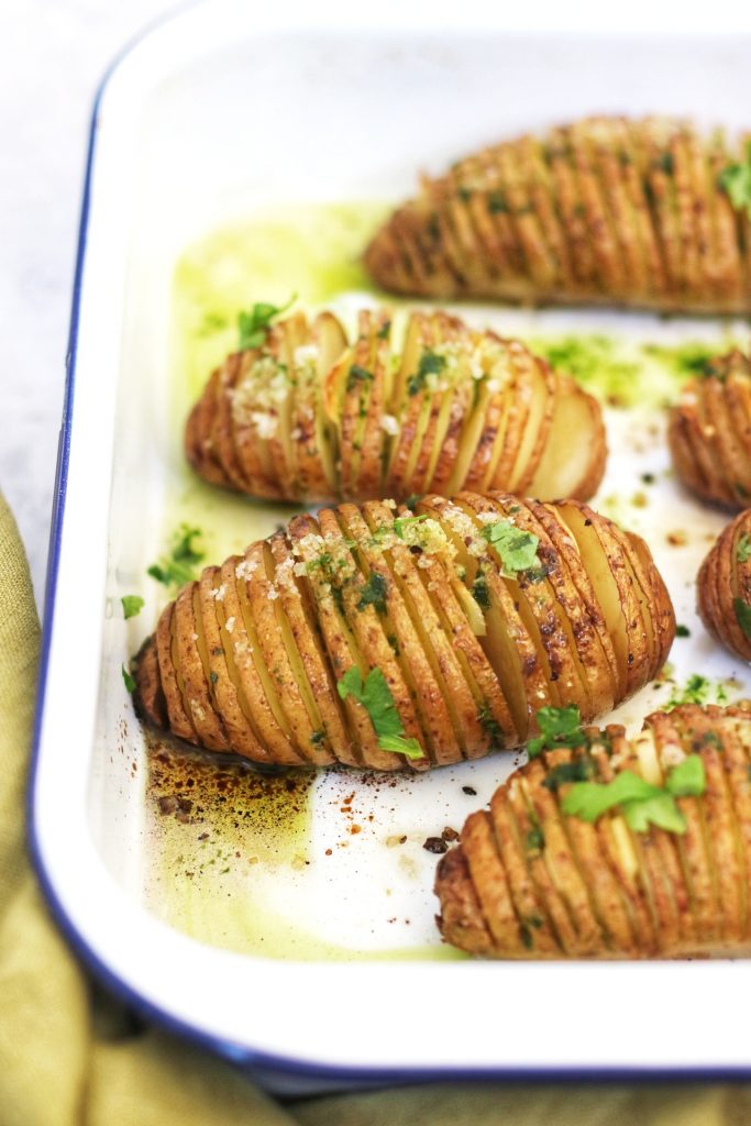 Hasselback Potatoes in an enamel oven dish drizzled with Wild Garlic Oil