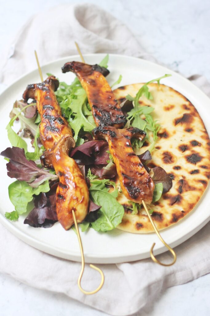 BBQ King Oyster Mushroom Kebabs on a bed of salad and flatbread