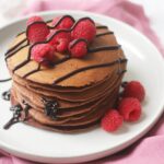 American Style Chocolate Pancakes with raspberries and chocolate sauce