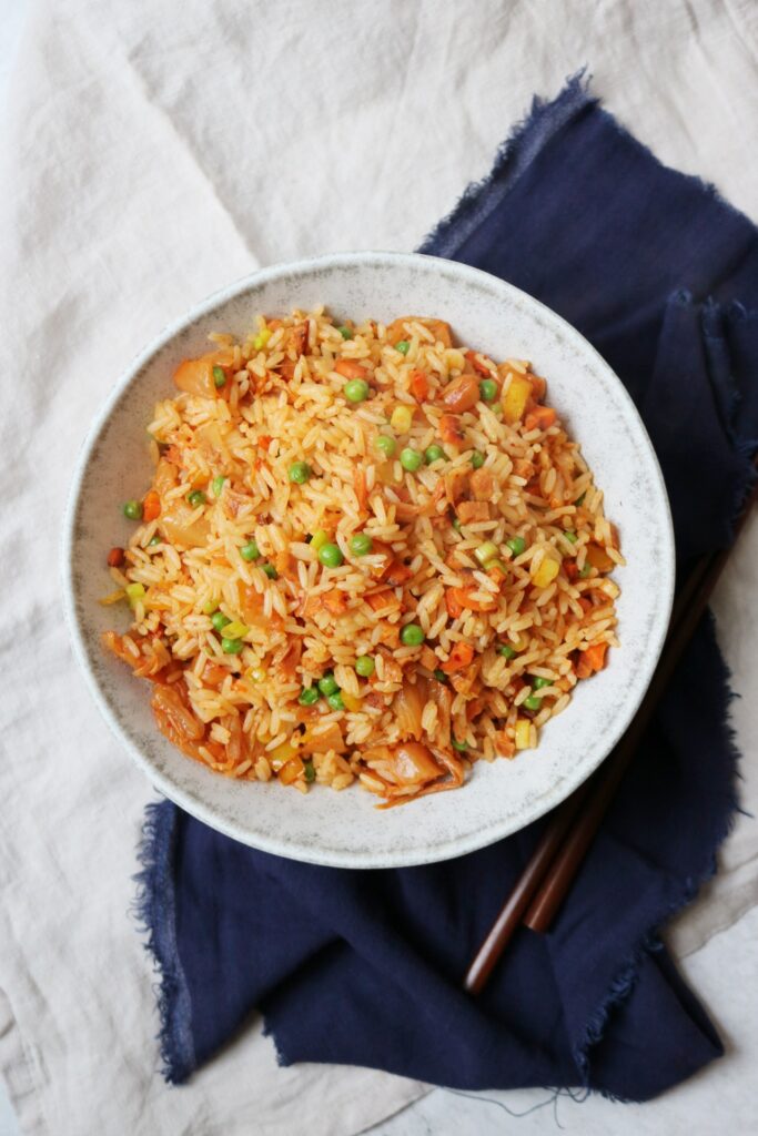 Vegan Kimchi Fried Rice in a bowl with chosticks