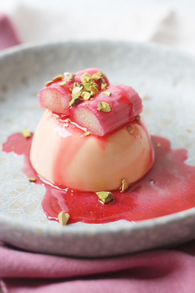 Vegan Panna Cotta topped with poached rhubarb and pistachio