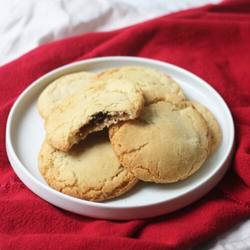 Vegan mince pie stuffed cookies on a plate with a bite taken out of one