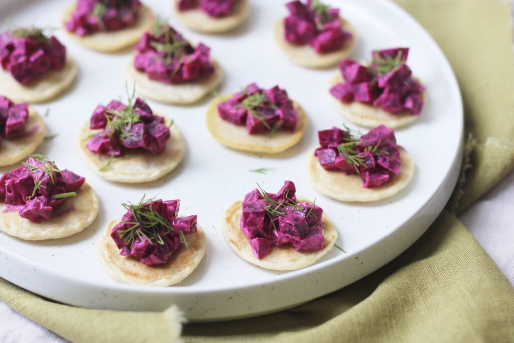 A plate of Vegan Creme Fraiche, Beetroot and Dill Blinis