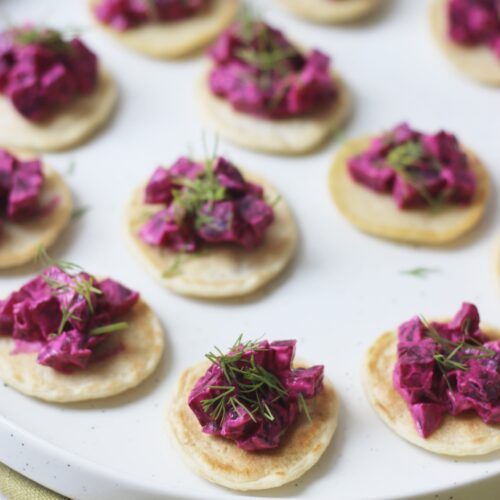 A plate of Vegan Creme Fraiche, Beetroot and Dill Blinis