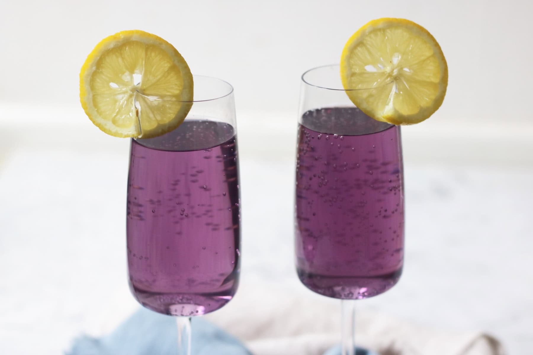 Two Lavender Lemon and Prosecco Cocktails with slices of lemon