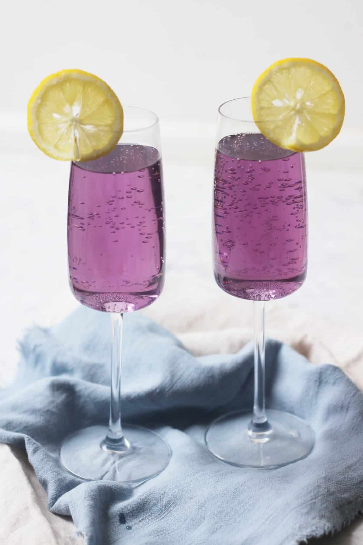 Two Lavender Lemon and Prosecco Cocktails with slices of lemon