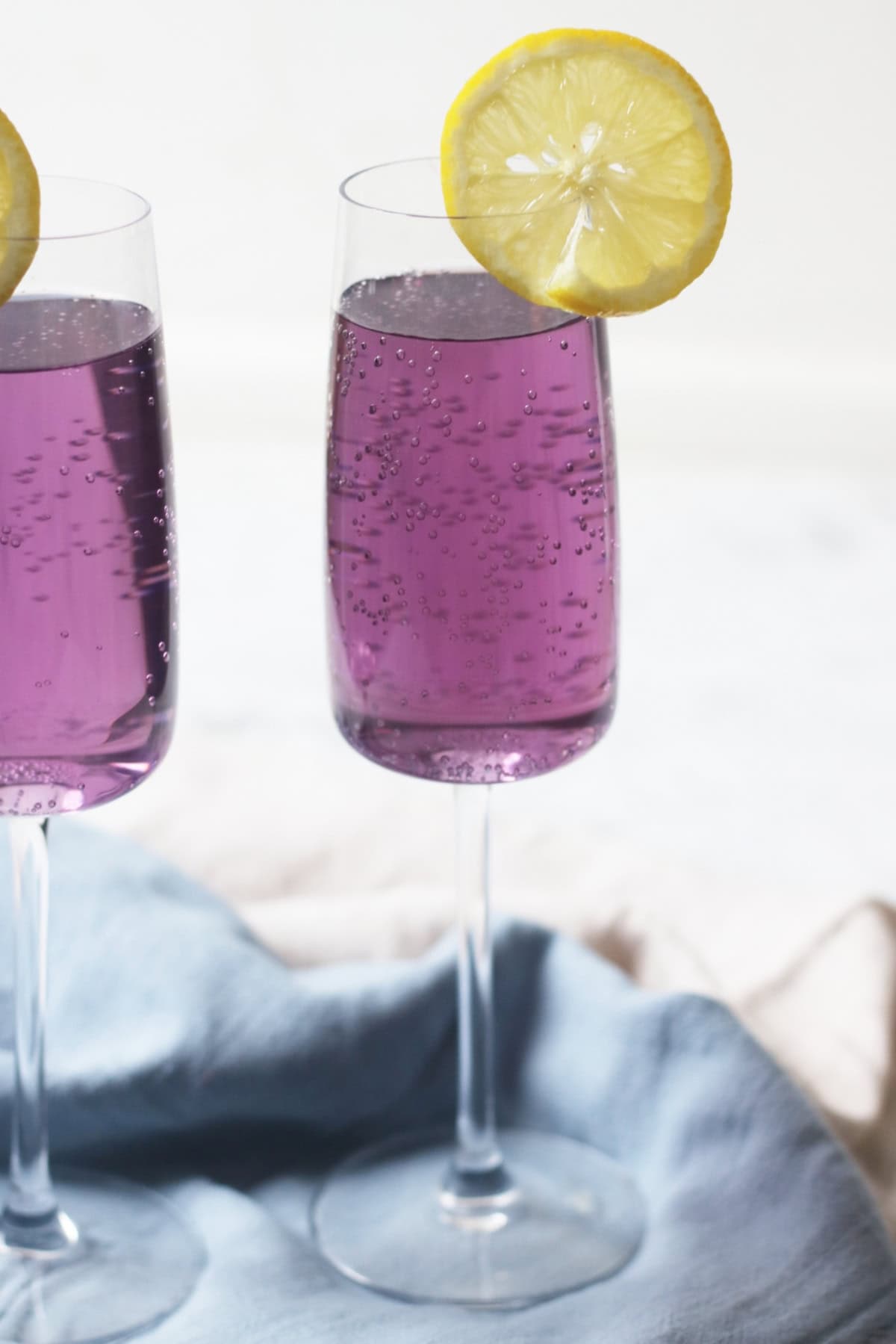 A Lavender Lemon and Prosecco Cocktail with a slice of lemon