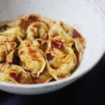 Close up bowl of Vegan Wontons in Chilli Sauce