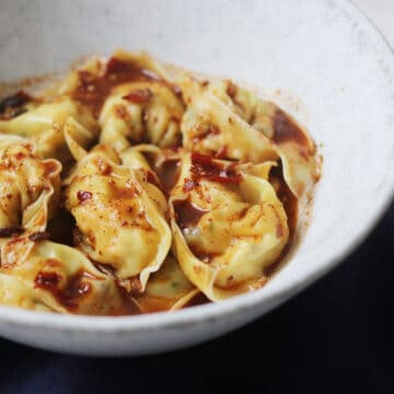 Close up bowl of Vegan Wontons in Chilli Sauce