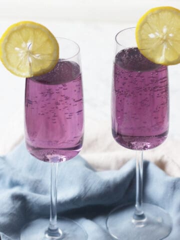 Two Lavender Lemon and Prosecco Cocktails with slices of lemon
