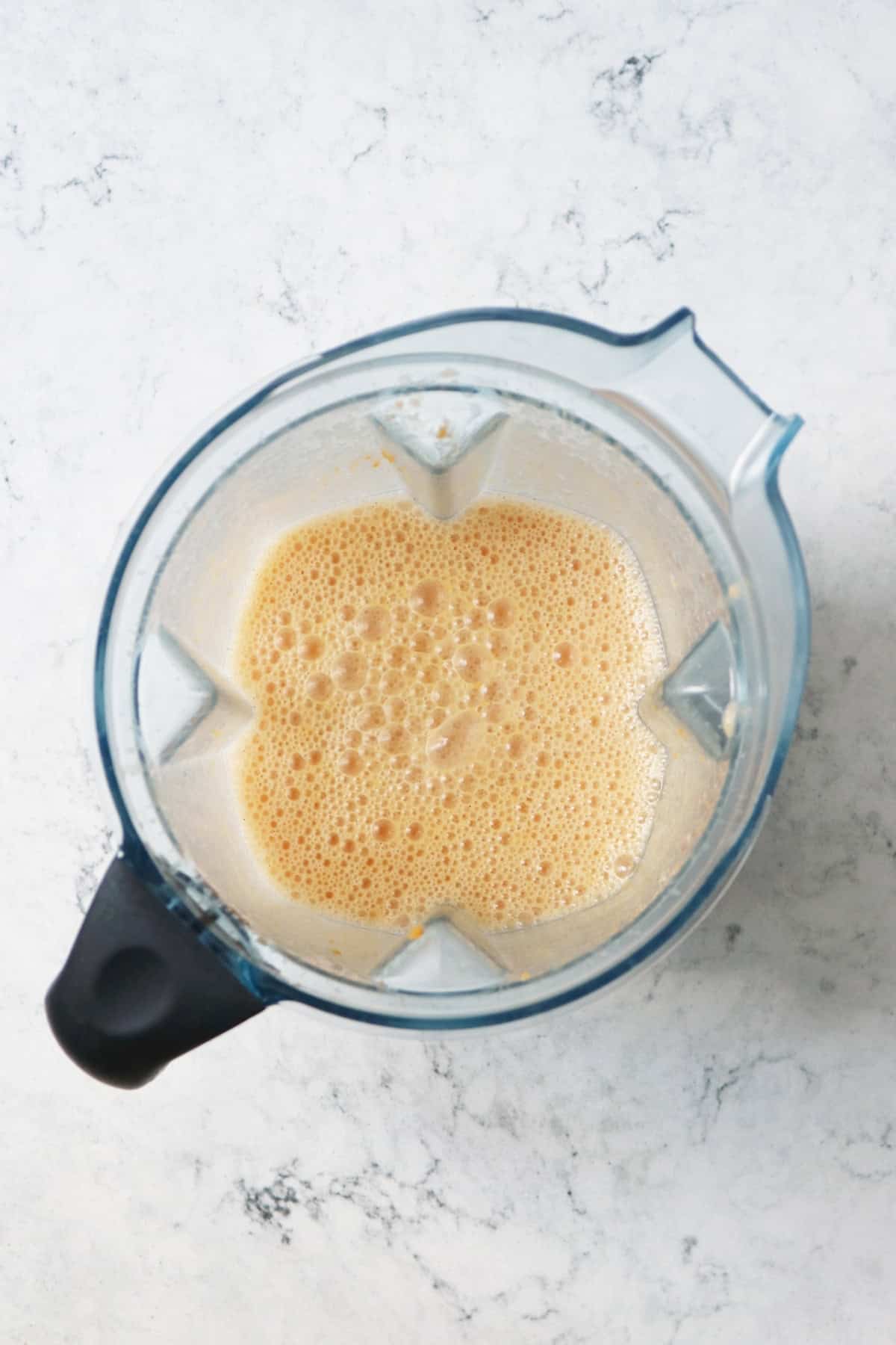 A blender full of the wet ingredients needed for vegan sweet potato pancakes