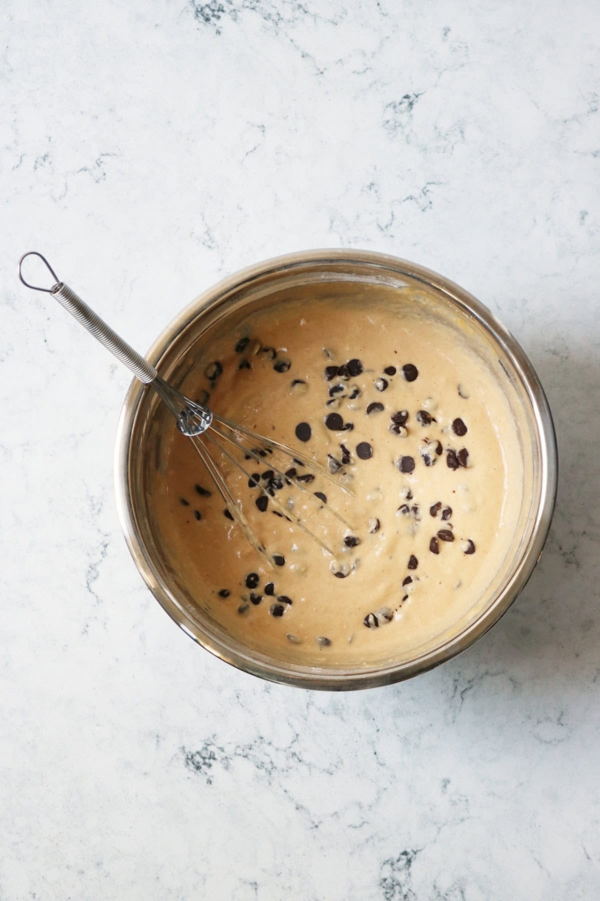 A bowl of vegan sweet potato pancake batter with chocolate chips