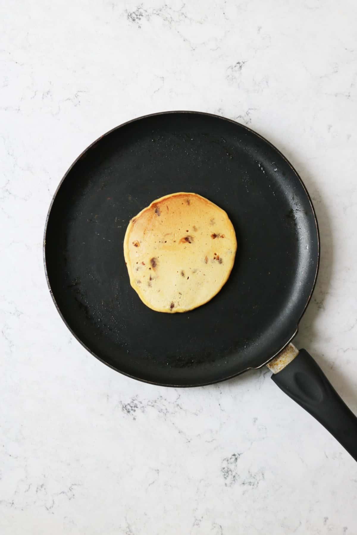 A vegan sweet potato pancake in a crepe pan