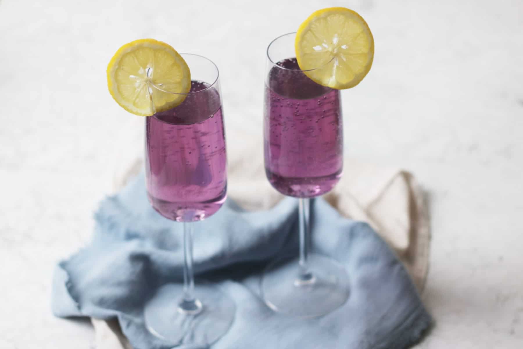 Two Lavender Lemon and Prosecco Cocktails with slices of lemon