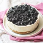 A whole vegan cheesecake topped with blueberry compote