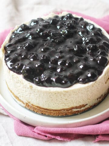 A whole vegan cheesecake topped with blueberry compote