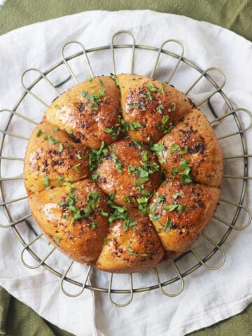 Vegan Tear and Share Garlic Bread on a wire rack and white and green napkins