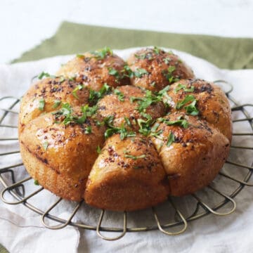 Vegan Tear and Share Garlic Bread on a wire rack and white and green napkins