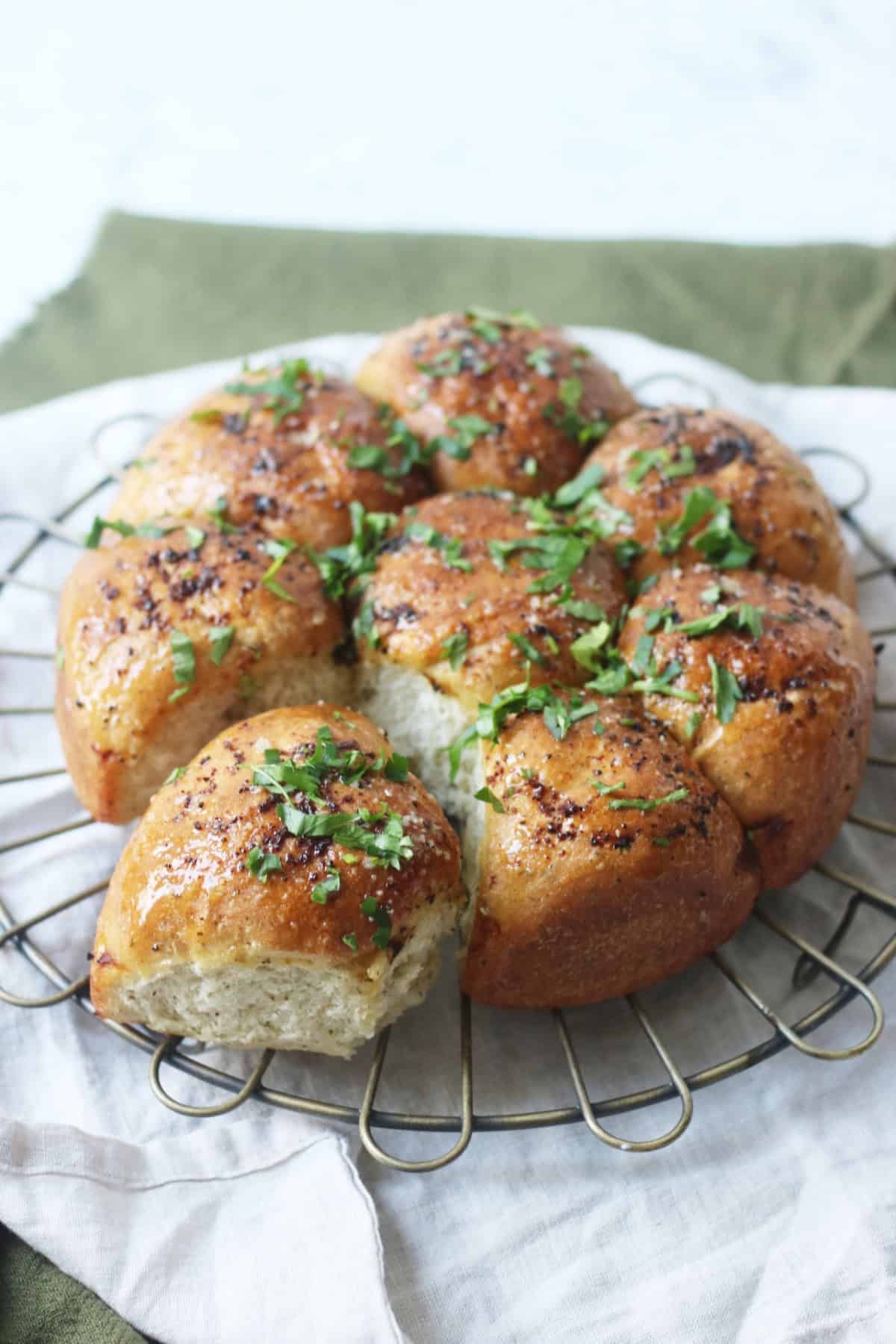 Vegan Tear and Share Garlic Bread on a wire rack and white and green napkins