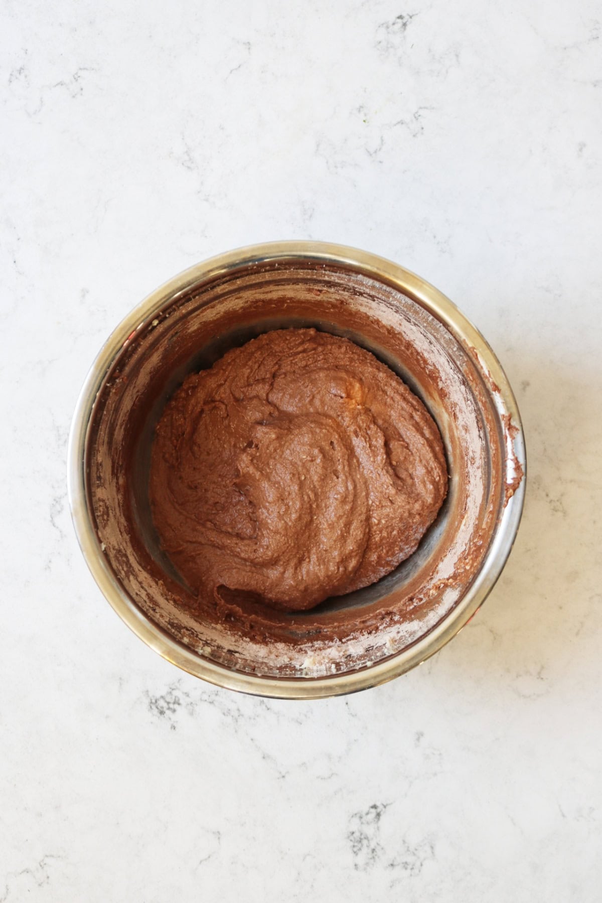 Chocolate cake batter in a metal mixing bowl