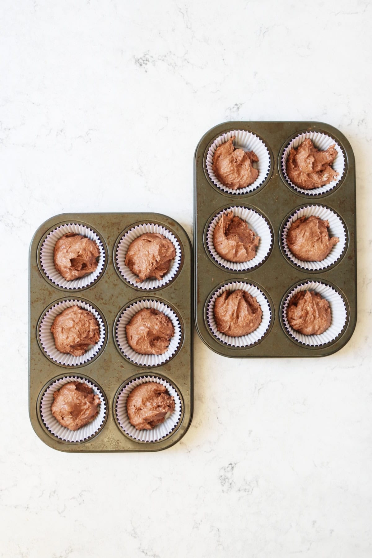 12 cupcake cases filled with chocolate cake batter