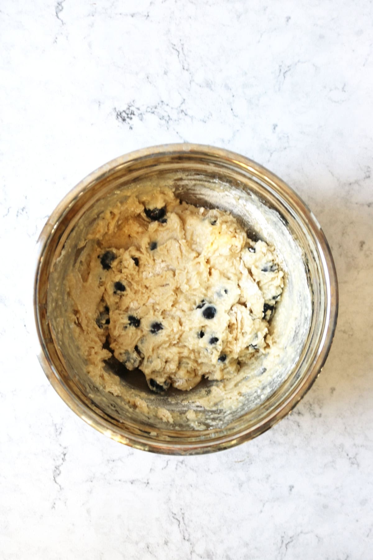 Vegan Blueberry Muffin batter in a metal bowl on a white counter top