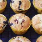 Vegan Blueberry and Lemon Curd Muffins in yellow paper cases on a wire rack