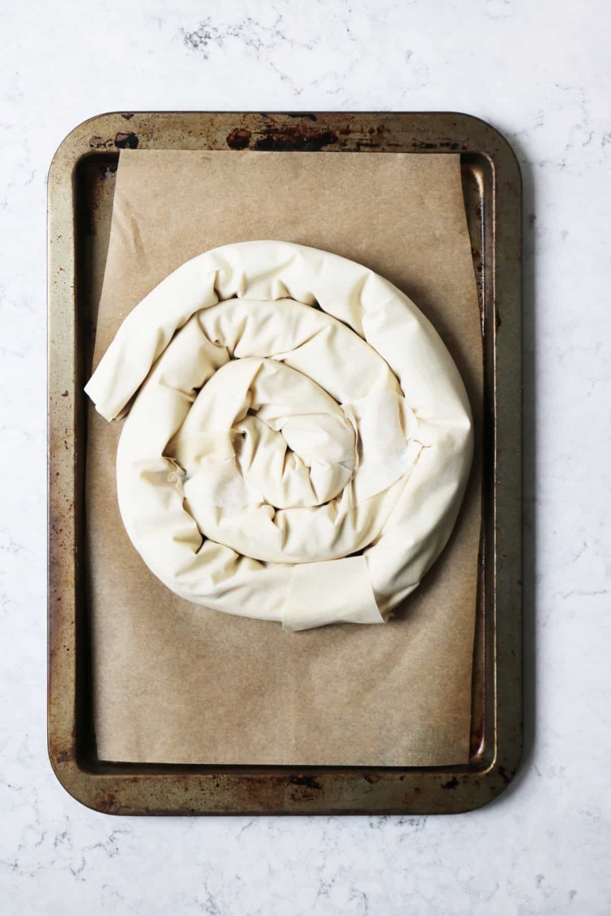A spiral vegan spanakopita ready for the oven