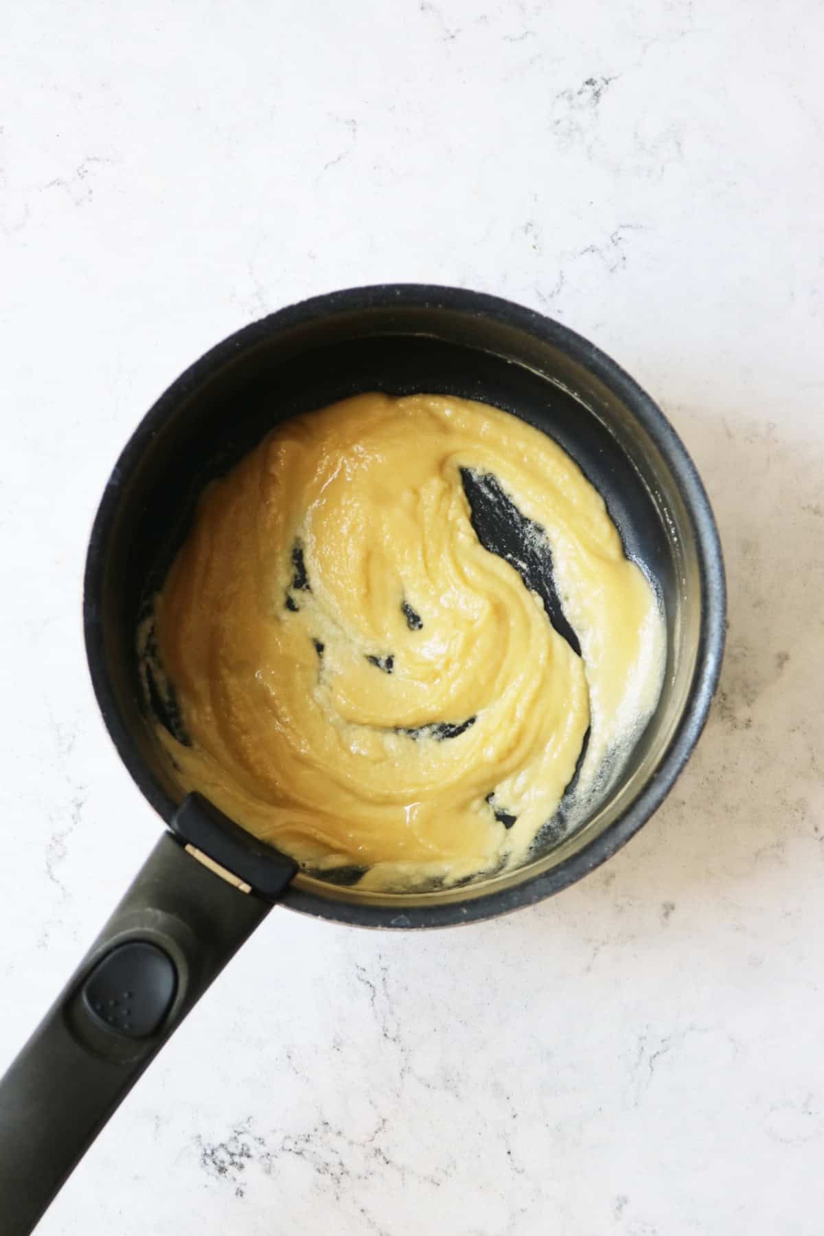 Roux in a sauce pan on a white marble counter top