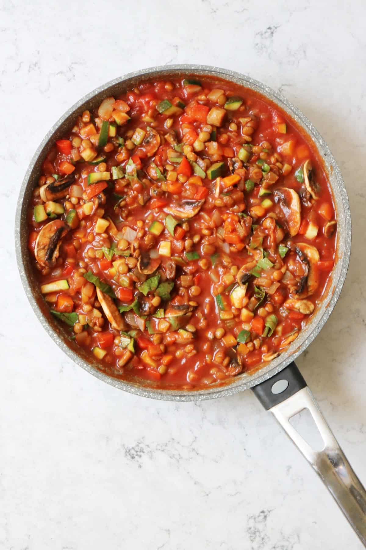 Tomato sauce simmering in a large frying pan
