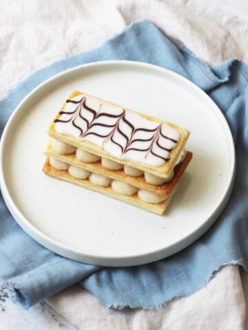 A Vegan Mille-Feuille on a white plate with a pale blue napkin