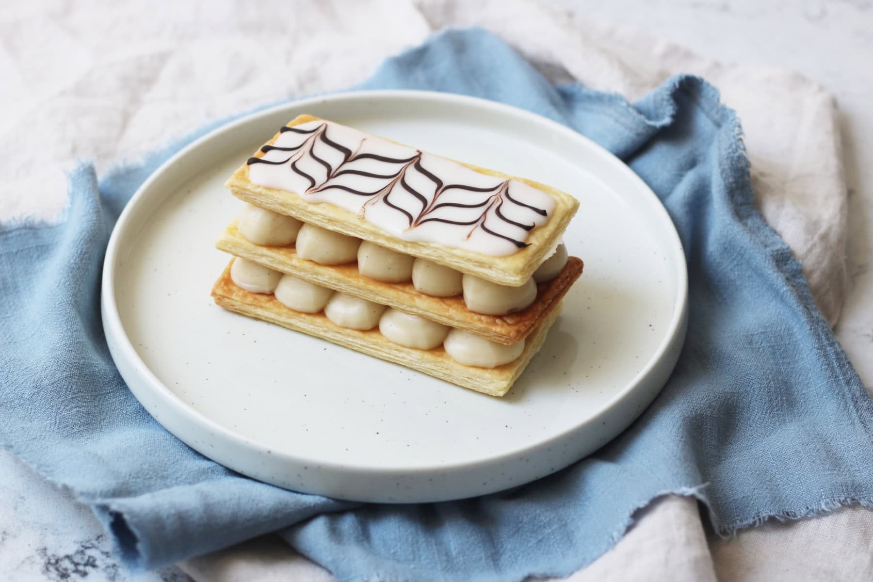 A Vegan Mille-Feuille on a white plate with a pale blue napkin