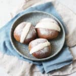 Three Vegan Maritozzi on a plate dusted with icing sugar.