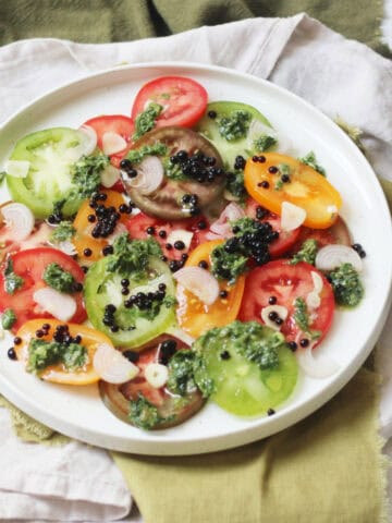 A plate of Tomato Salad with Salsa Verde and Balsamic Pearls