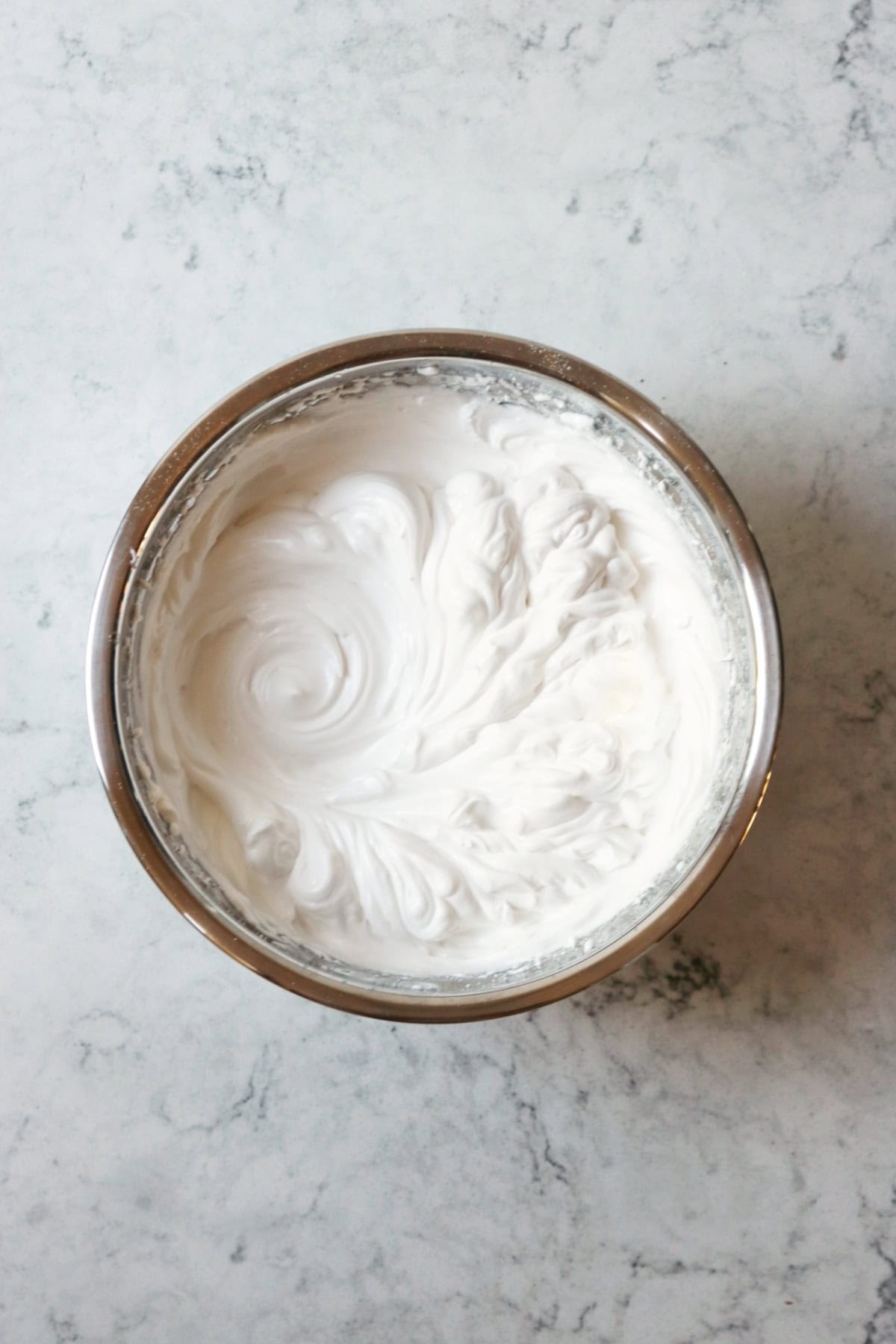 Uncooked vegan meringue in a metal mixing bowl