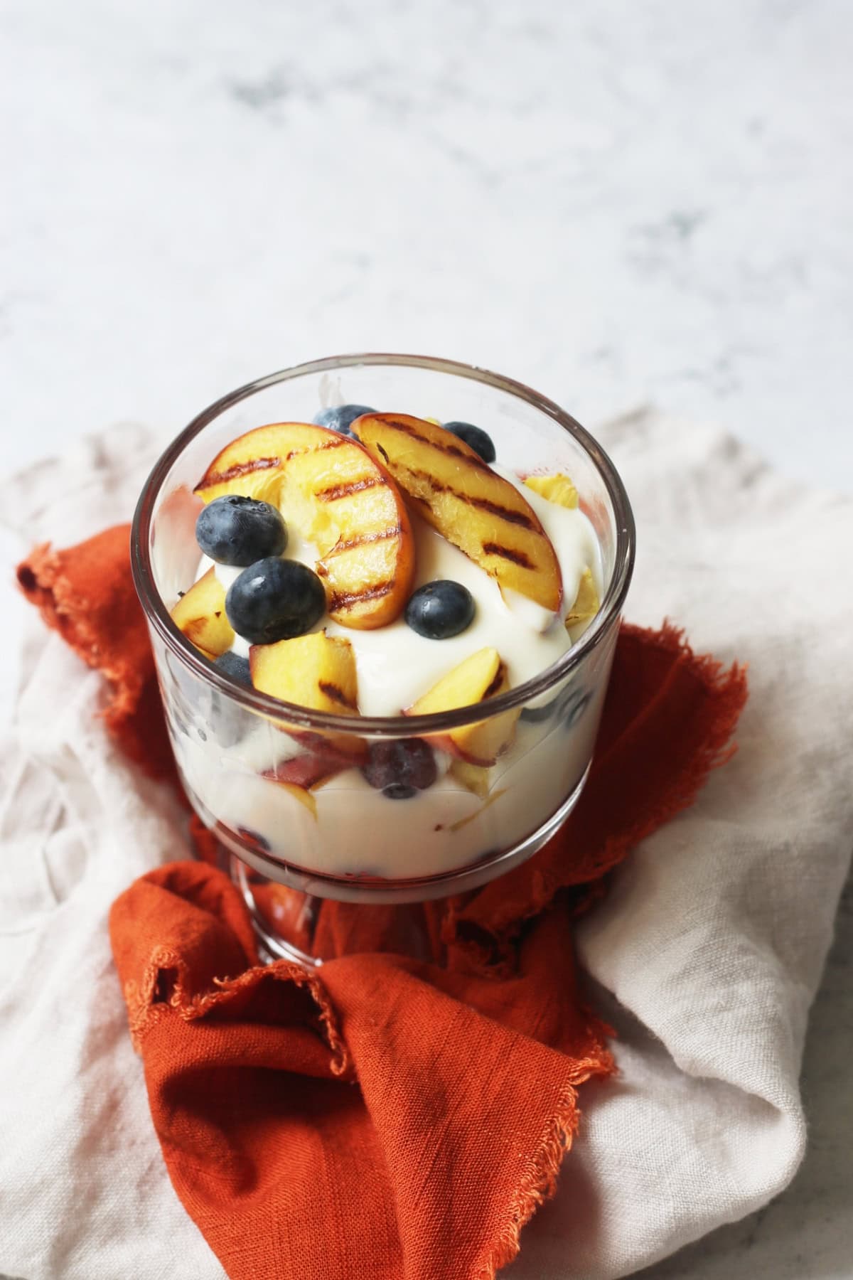 Vegan Grilled Peach and Blueberry Parfait in a glass pudding bowl