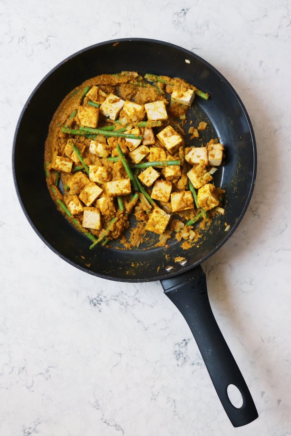 Cooking off curry paste in a large frying pan