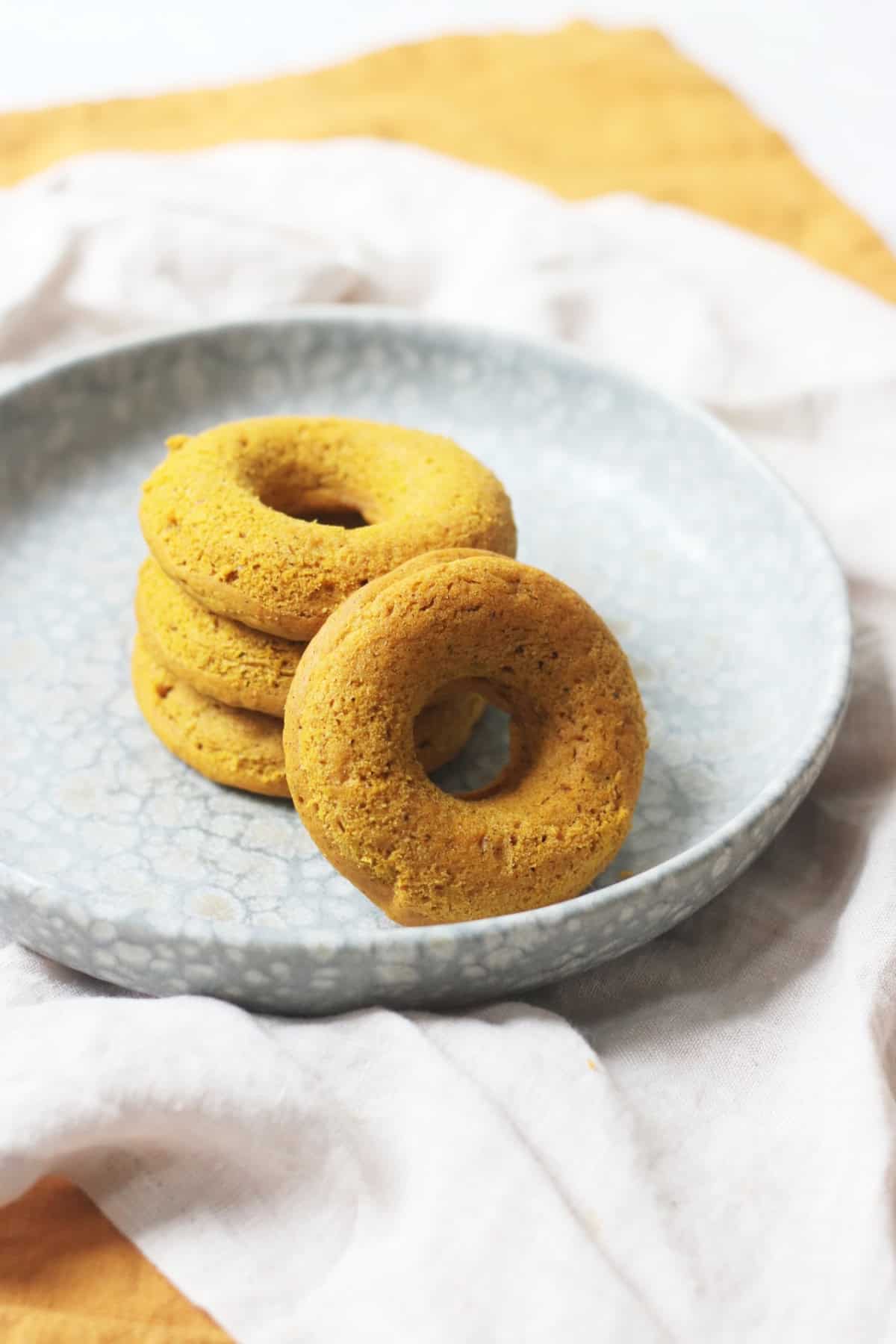 A stack of Vegan Baked Pumpkin Spice Doughnuts