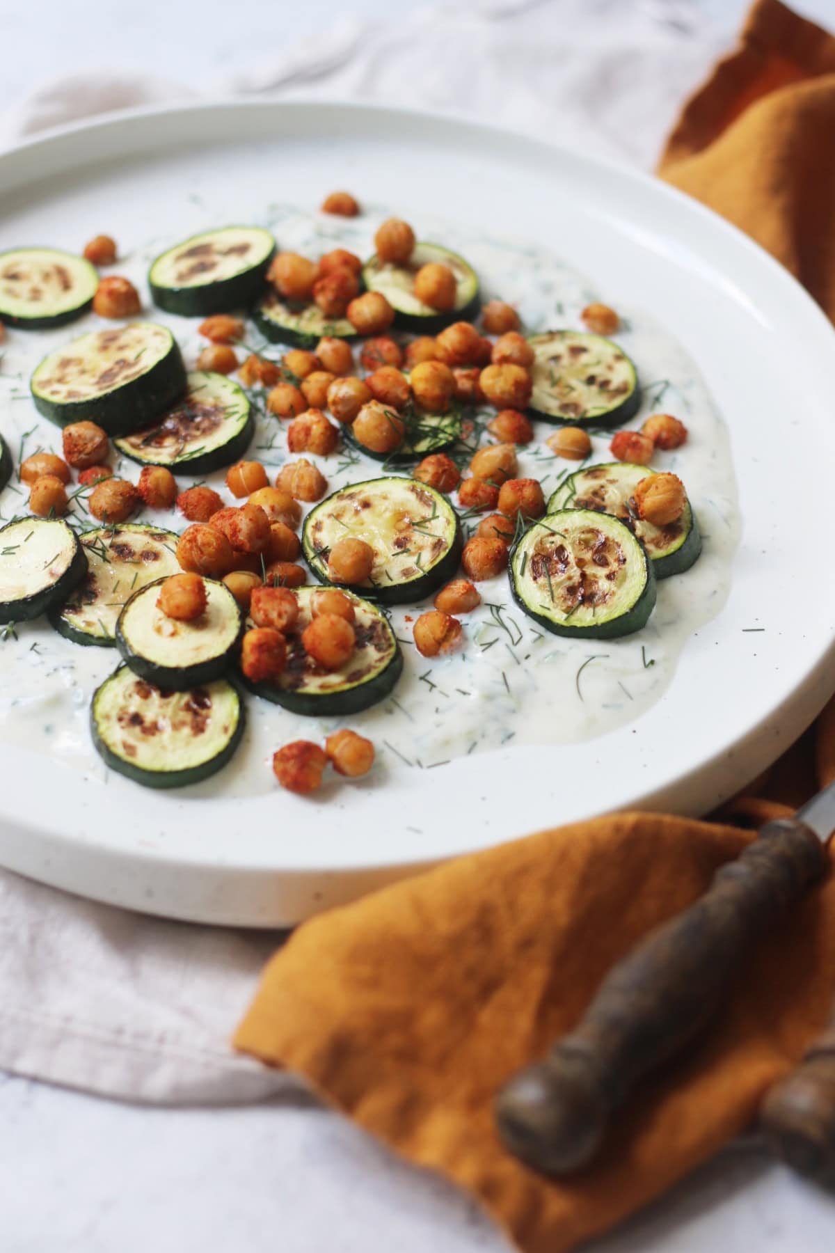Baby courgettes crispy chickpeas and vegan tzatziki on a plate
