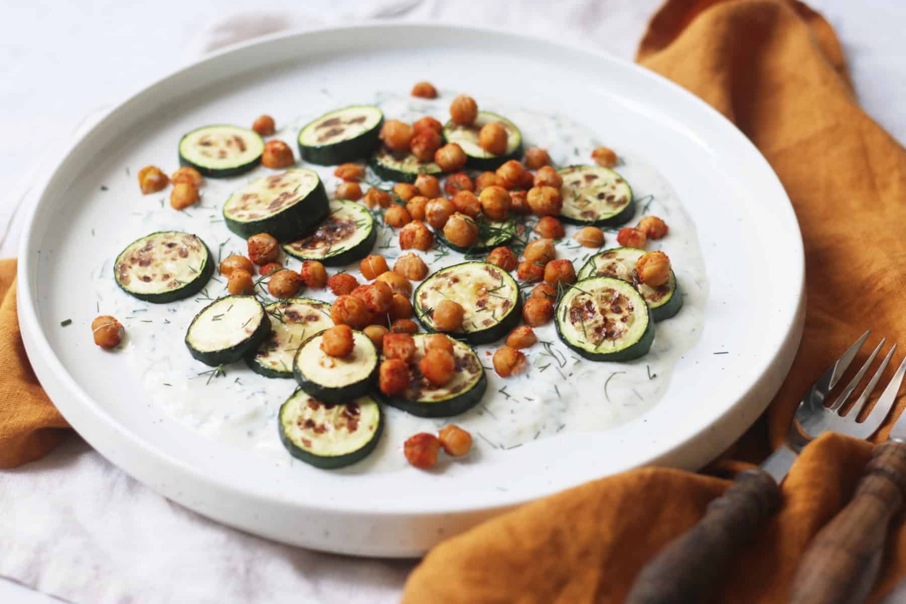 Baby courgettes crispy chickpeas and vegan tzatziki on a plate